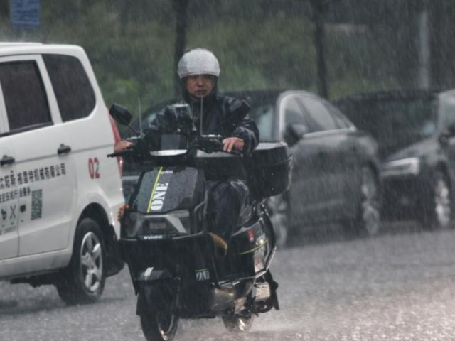 a man rides amid downpour in shenyang northeast china s liaoning province july 26 2024 photo xinhua